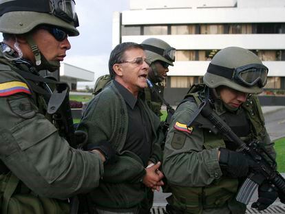 En una fotografía de diciembre de 2004, policías escoltan a Rodrigo Granda a una estación policial en Bogotá.
