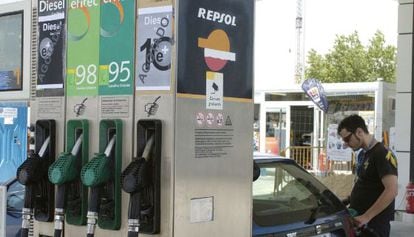 Un joven, repostando en un surtidor de Repsol.