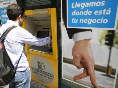 Un ciutadà utilitza un caixer automàtic de CaixaBank a Madrid.