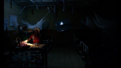 A health worker tries to work with little light at the Kabala Public Hospital, Sierra Leone.