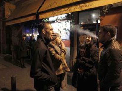 Fumadores charlando en la puerta de un bar.