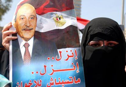 Una partidaria de Omar Suleiman sostiene un poster que lo llama a participar en las elecciones.