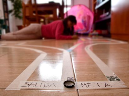 Una niña juega en una pista de chapas montada en su casa de Almería.