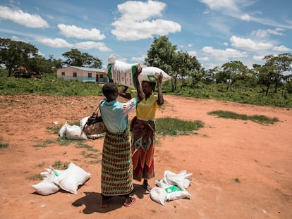 Dos mujeres cargan con una bolsa de alimentos en el pueblo zambiano de Simumbwe.