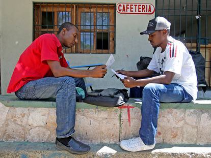 Dos jóvenes revisan documentos en el campus de la Universidad de Haití, en Puerto Príncipe.