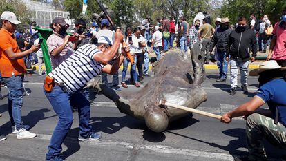 Miembros del Consejo Indígena destruyen la estatua de Fray Antonio de San Miguel en Morelia, el lunes.