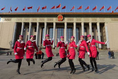 Azafatas chinas saltan frente al Gran Salón del Pueblo de Pekín antes de la sesión inaugural del congreso. Banderas rojas e insignias comunistas, el tránsito prohibido en la plaza de Tiananmen -salvo para los delegados y la prensa acreditada- o el aumento de presencia policial son algunos de los signos que marcan hoy en Pekín el inicio del cónclave de siete días, del que saldrán los líderes de la próxima década.