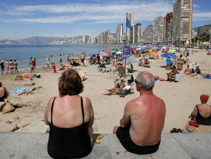 Una pareja de jubilados disfrutan del sol y las altas temperaturas en la playa de Levante en Benidorm, en Alicante. 