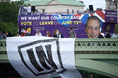 Un autobús con publicidad a favor del 'Brexit' pasa por detrás de unos partidarios de la permanencia.