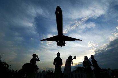 Varias personas fotografían un avión que se dispone a aterrizar en el aeropuerto Songshan de Taipei, Taiwán.