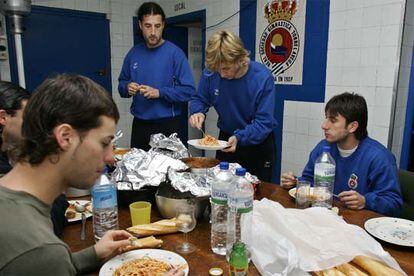 Jugadores de la Gimnástica de Torrelavega comen en el pasillo de los vestuarios.