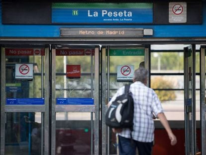 Un hombre entra a la estación de La Peseta, en la línea 11 del metro de Madrid.
