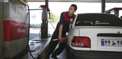 Un empleado de una gasolinera llena el depósito de un coche en Teherán.