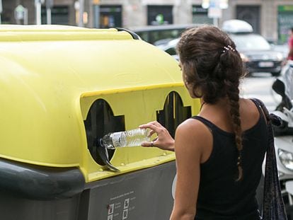 Una chica tira una botella en el contenedor amarillo en Barcelona, el 30 de julio de 2018.
