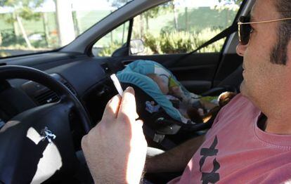 Un conductor fuma en el interior de un veh&iacute;culo junto a un beb&eacute;.