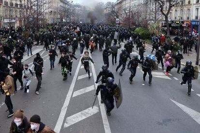 Agentes de la policía antidisturbios persiguen a algunos manifestantes que participan en las protestas de este martes, en París.