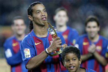 Ronaldinho, con el trofeo de la FIFA al mejor jugador de 2004, es aplaudido por sus compañeros.