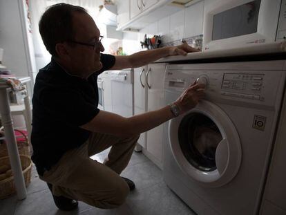 Un hombre pone una lavadora en su domicilio.