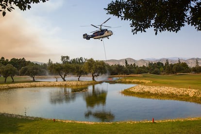 Un helicóptero recogía agua el viernes en el campo de golf Laurogolf, en Alhaurín el Grande (Málaga). El incendio de la Sierra de Mijas ha obligado al desalojo de más de 1300 personas en Alhaurín el Grande y Alhaurín de la Torre. 