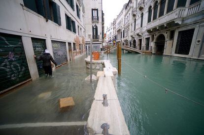 Una mujer camina por uno de los canales inundados de la ciudad de Venecia, este viernes. 