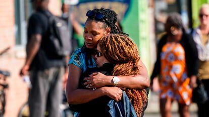 Dos mujeres se abrazan ante el lugar del tiroteo en Búfalo.