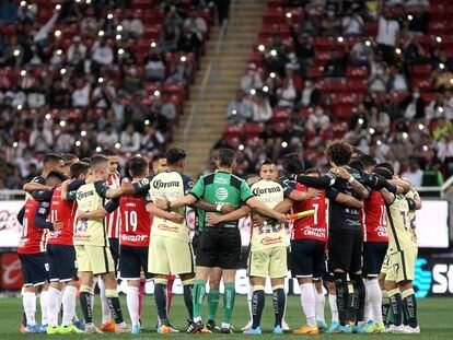 Jugadores de las Chivas, del América y los árbitros se abrazan para pedir paz en el fútbol mexicano.