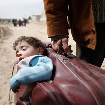On 15 March 2018 in Beit Sawa, eastern Ghouta, a man carrying a child in a suitcase walks towards Hamourieh where an evacuation exit from eastern Ghouta has been opened.

In March 2018, thousands of people reportedly left Hammouriyeh in eastern Ghouta, following reports of fierce fighting that resulted in civilian deaths and injuries, as well as damage to civilian infrastructure. The actual number of people who have exited eastern Ghouta is not known, at the time of reporting busses were still arriving for more evacuees.  The United Nations has not observed the evacuations, but is visiting collective shelters where some of the evacuees are arriving. This includes the Dweir collective center, where families are being assisted by the Syrian Arab Red Crescent with non-food items, hygiene kits, and ready-to-eat food. The shelter has a staffed medical point, water and electricity.  Since the beginning of the first evacuations on the 11 March, UNICEF and partners started its emergency response. Many of these actions are still ongoing as evacuees continue to arrive at the reception centres. At Dweir reception centre, with the local Department of Health UNICEF distributed High Energy Biscuits, plumpy paste, Multi-micro Nutrient tablets and powder. Women and Children are being checked and screened for malnutrition and provided with proper supplies when needed. Further supplies are being sent to Dweir to continue the direct distribution to evacuees. Children under-5 are also being vaccinated with the Oral Polio Vaccine and given their routine immunizations if they had not received them. A mobile health team has also been deployed to Dweir to provide further health and nutrition services to children and mother. 5,000 brochures with awareness messages on prevention of child separation (including plastic bracelets with tags for parents to write names and contact information of a child’s parents) have been dispatched to the reception centre. Winter clothes sets are being dist
