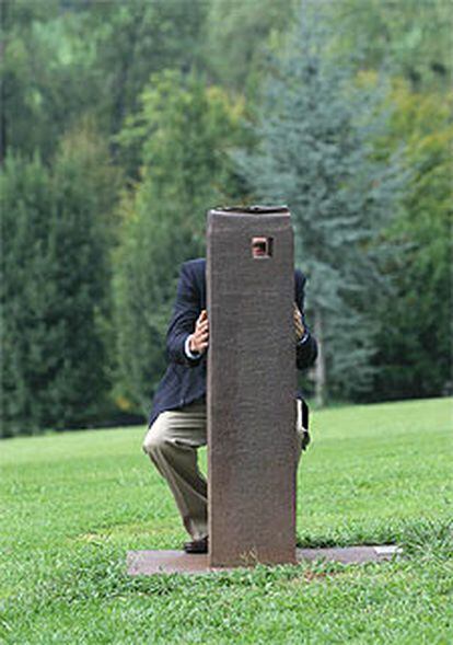 Luis Chillida observa a través de la escultura <i>Emparantza (Esperanza)</i> en el parque del museo.