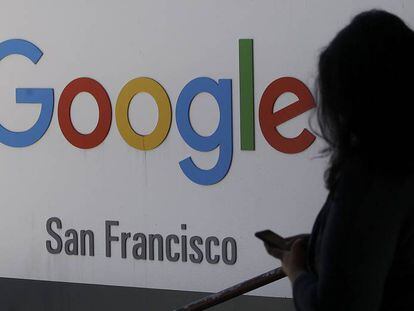 Una persona pasa junto a un logo de Google en San Francisco.