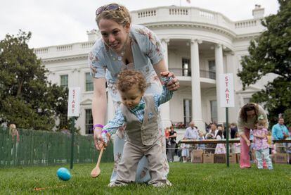 Amy Vitale, de Virginia, ayuda a su hija Auden Vitale, de 14 meses, a participar en la carrera de huevos de Pascua, durante la Ronda de Huevos de Pascua de la Casa Blanca, en Washington.