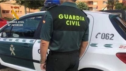 An agent of the Civil Guard next to his vehicle.