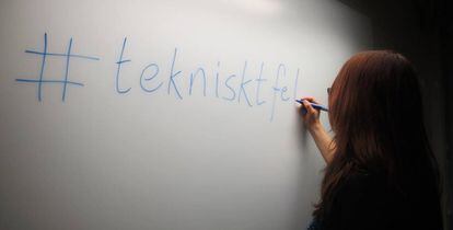 Una mujer dibuja en la pizarra el hastag que agrupa al movimiento sueco contra la discriminación en la tecnología.
