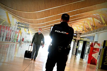 Un policía controla el acceso a la T-4 del Aeropuerto Adolfo Suárez Madrid-Barajas, el viernes 10 de octubre, para vigilar el cumplimiento de las restricciones a la movilidad impuestas por el estado de alarma en Madrid que decretó el Gobierno.