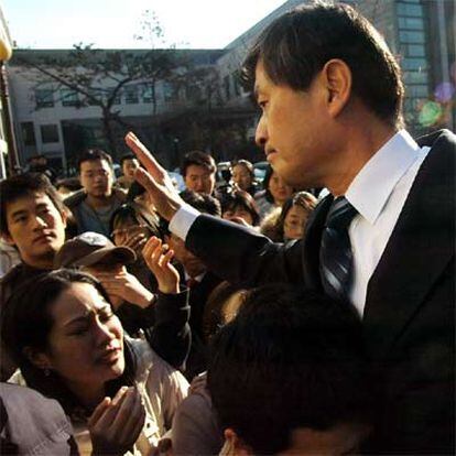 Hwang Woo-suk saluda a sus estudiantes al abandonar ayer la Universidad de Seúl.