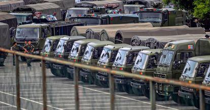 Miembros de la Fuerza de Policía Armada del Pueblo (PAP) pasan junto los vehículos militares en el Centro Deportivo de la Bahía de Shenzhen en Shenzhen, provincia de Guangdong (China). Pekín "no se quedará cruzada de brazos" si la situación "empeora" y tiene "suficientes medios y suficiente poder para reprimir los disturbios rápidamente", afirmó este jueves el embajador chino en Londres, Liu Xiaoming.