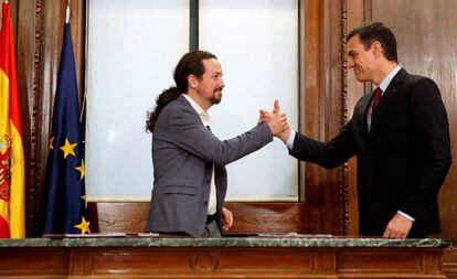 Pablo Iglesias y Pedro Sánchez se saludan tras firmar el acuerdo programático.