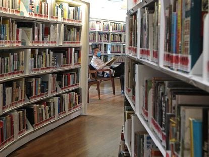 Un hombre lee un libro en una biblioteca de Singapur.