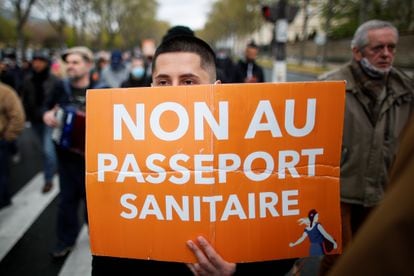 Un manifestante contra las restricciones impuestas por el coronavirus en Francia sujeta un cartel con el lema "No al pasaporte sanitario".