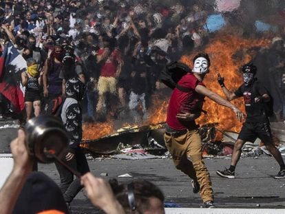 Un joven lanza piedras contra la policía durante una protesta en Santiago de Chile.