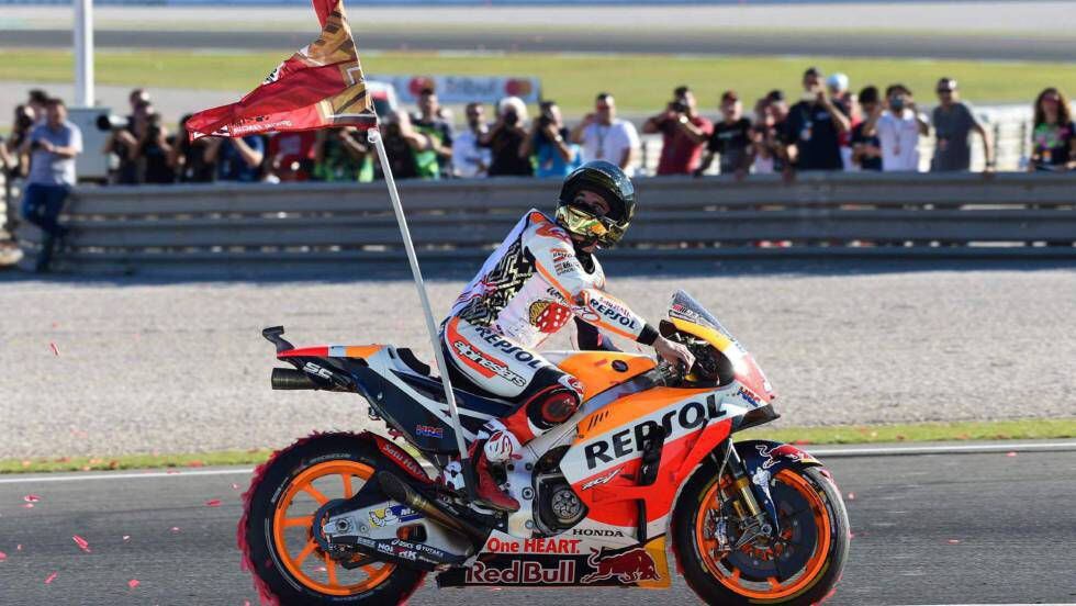 Márquez celebra su título mundial con una bandera de su club de fans.