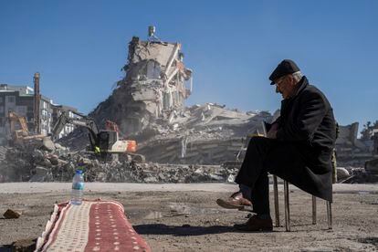 Mehmet Nasir Duran, de 67 años, sentado una silla junto a los retos de un edificio destruido en Nurdagi (Turquía). 