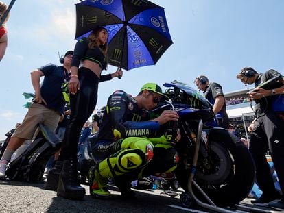 Una azafata protege del sol a Rossi antes de la carrera del GP de España, en Jerez, el año pasado.