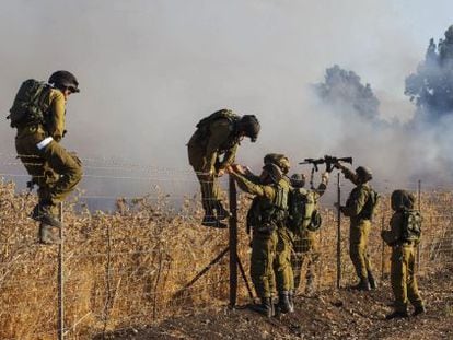 Soldados en el lugar del incendio causado por el lanzamiento de misiles desde Siria, al norte de Israel.