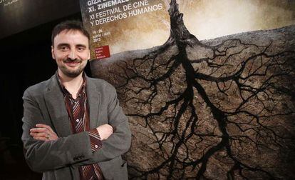 Josemi Beltrán, director del Festival de Cine y Derechos Humanos de San Sebastián, posa delante del cartel de la edición de este año.