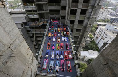 Jornada de yoga entre dos edificios en construcción en la ciudad india de Ahmadabad, el 21 de junio de 2018.