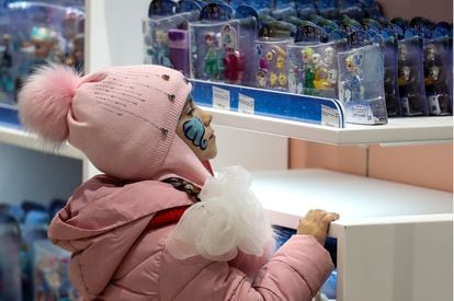 Una niña mira con atención algunos juguetes de la saga 'Frozen'.