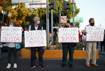 Conductores de autobuses y familiares, levantan carteles para exigir una aumento a las tarifas del transporte público, durante uno de los bloqueos en Ciudad de México, el 2 de junio de 2022.