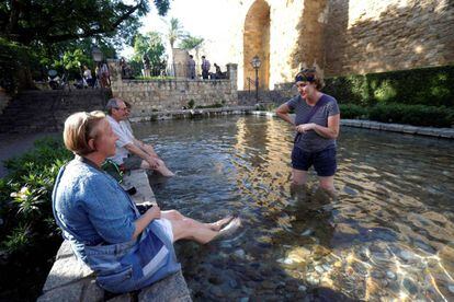 Unos turistas se refrescan en una de las fuentes de Córdoba.