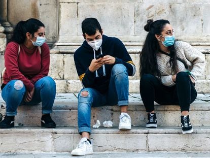 Tres adolescentes sentados en una escalera.