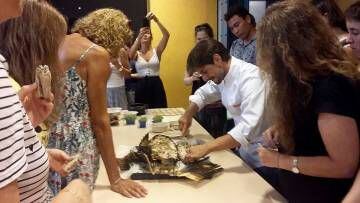 El cocinero Vinicius Martini abriendo la carpa ante los asistentes al taller de recetas del neolítico.